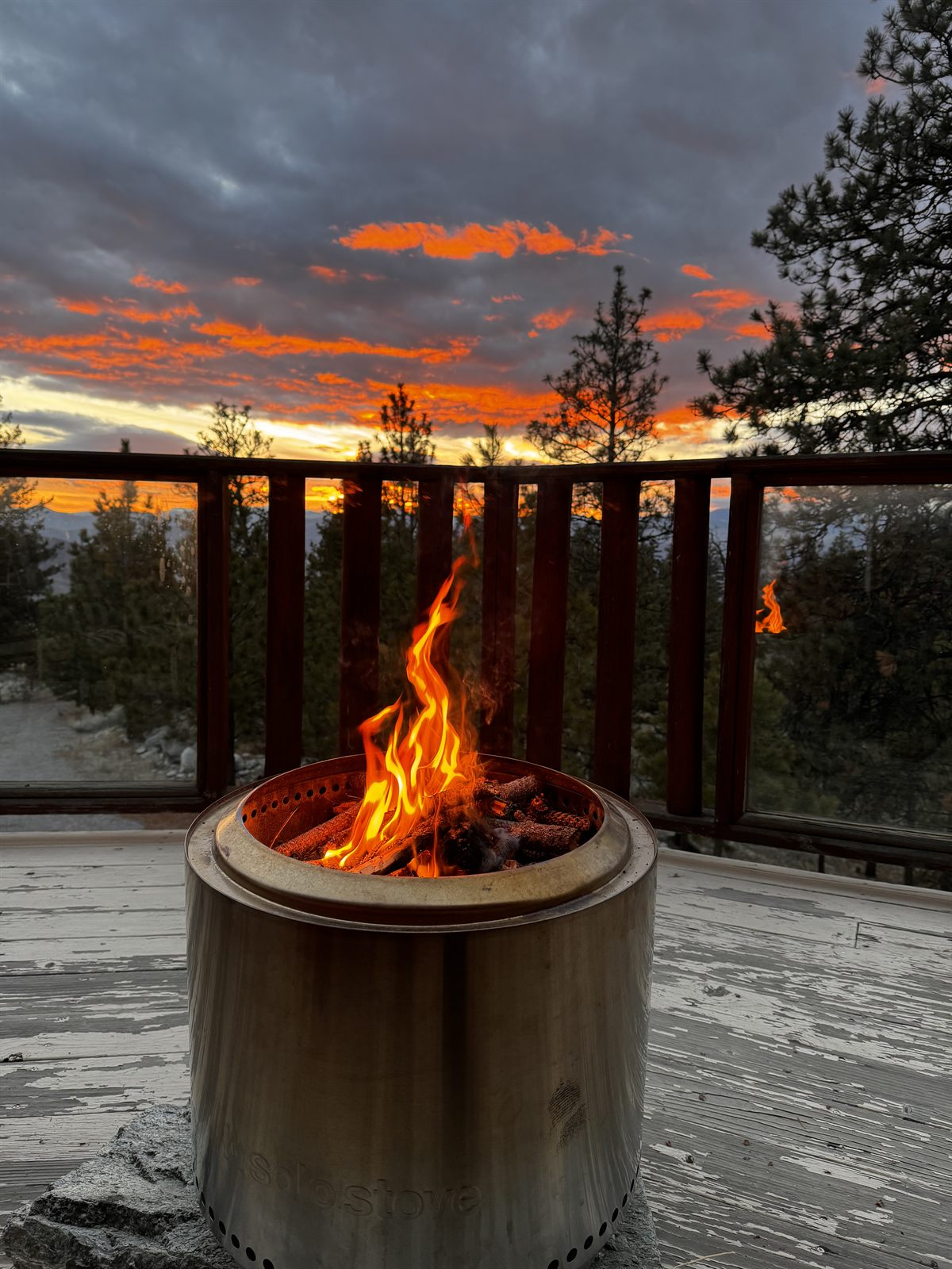 A fire burning in the deck firepit at sunset over the valley.