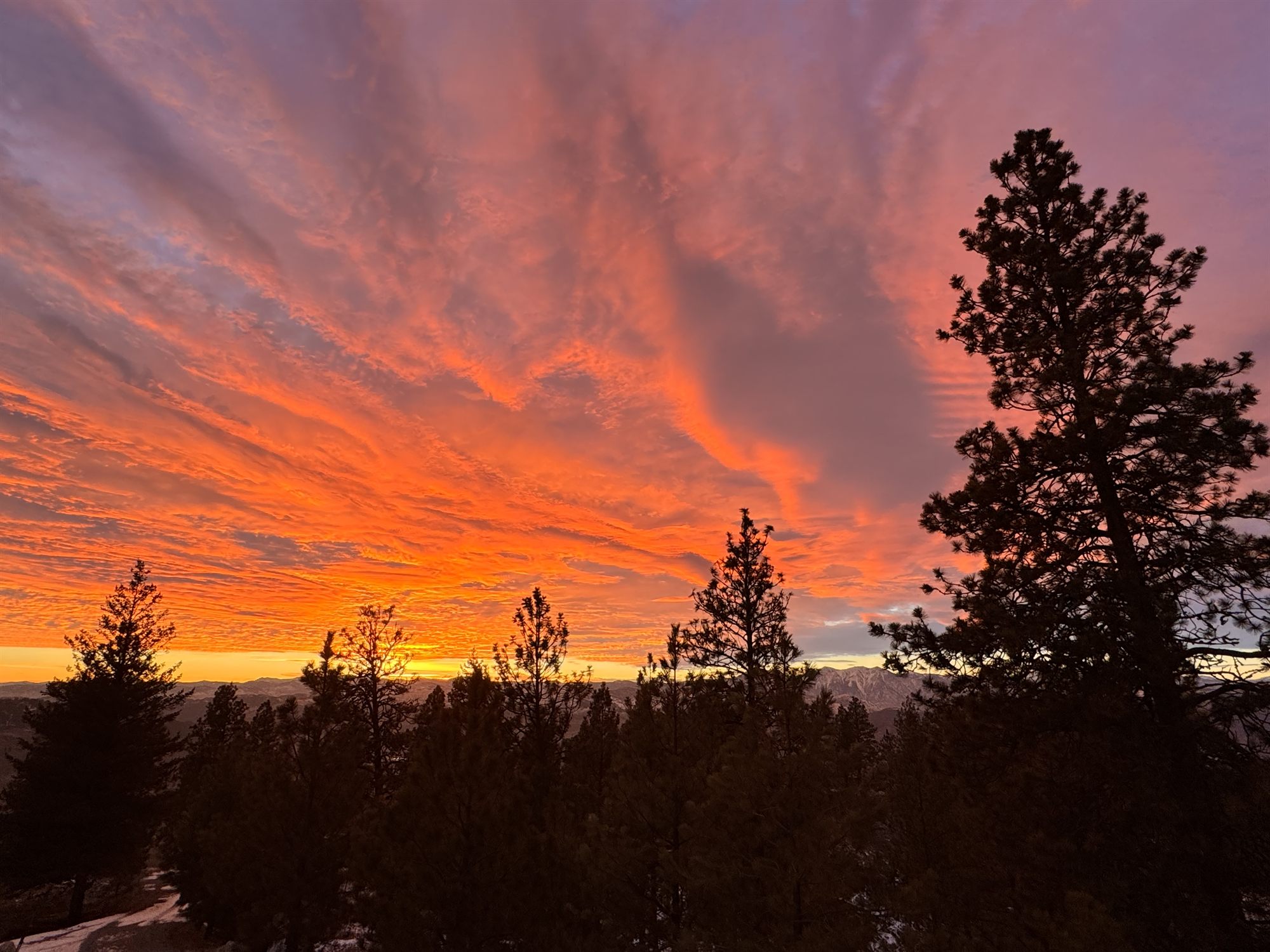 A fiery sunset over the forested ridgelines at the property.